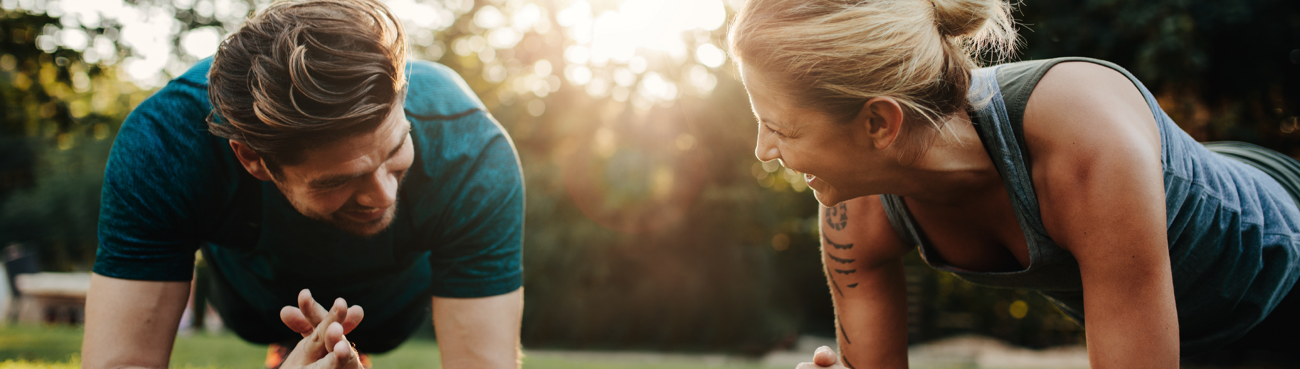 Mann und Frau beim Bodyweight-Training im Freien.