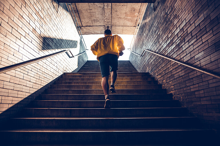 Mann joggt Treppen hoch.