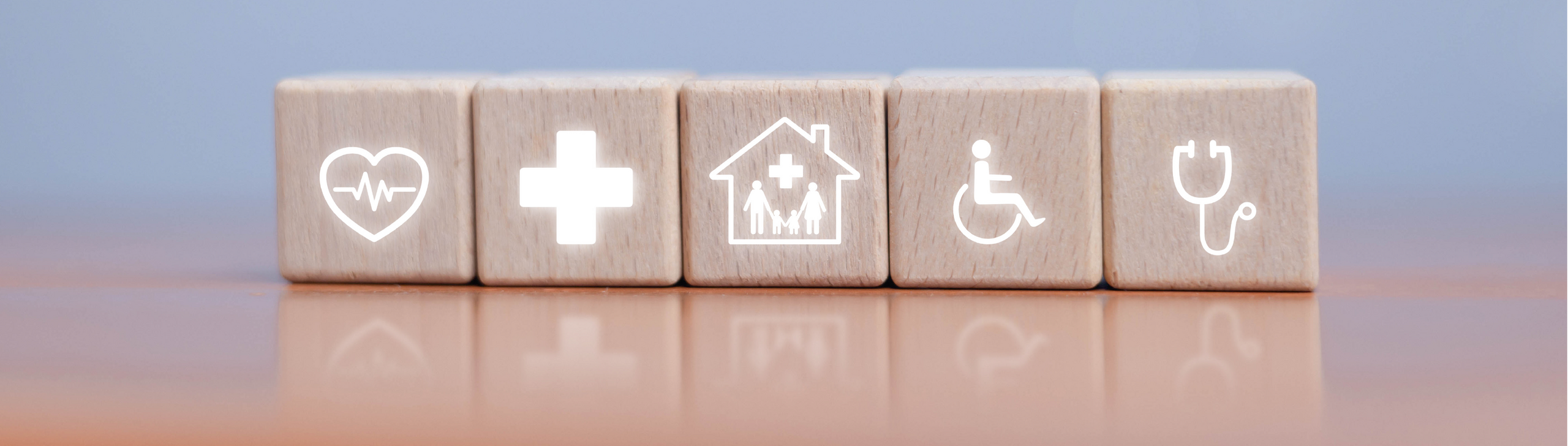 Holzwürfel mit Gesundheits- bzw. Versorgungssymbolen.