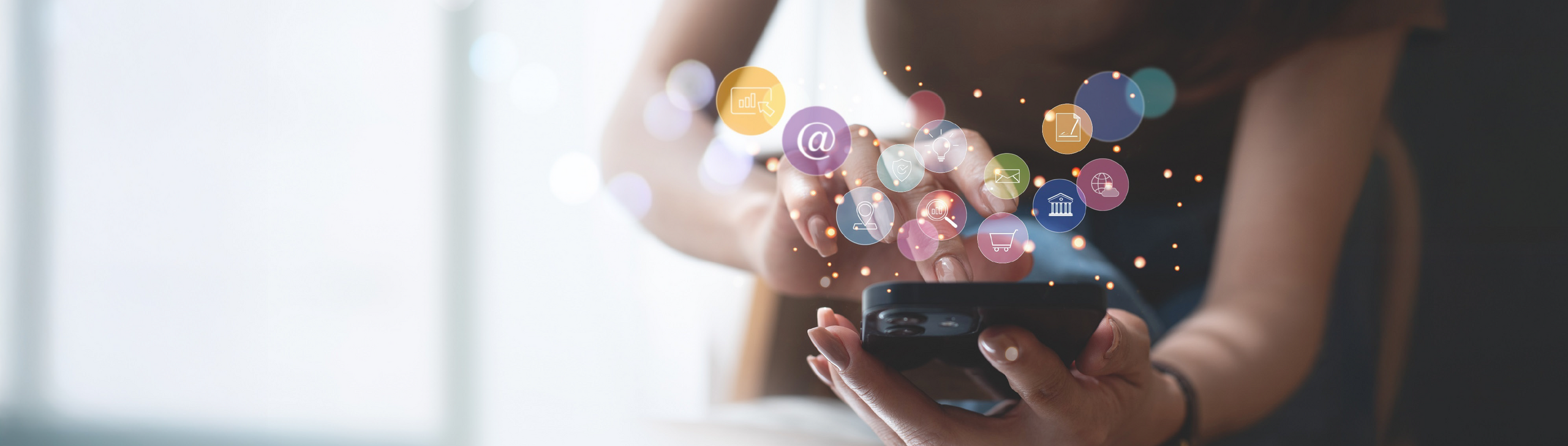 Nahaufnahme eines Smartphones, welches von einer weiblichen Hand gehalten wird. Darüber sind Social-Media-Symbole abgebildet.