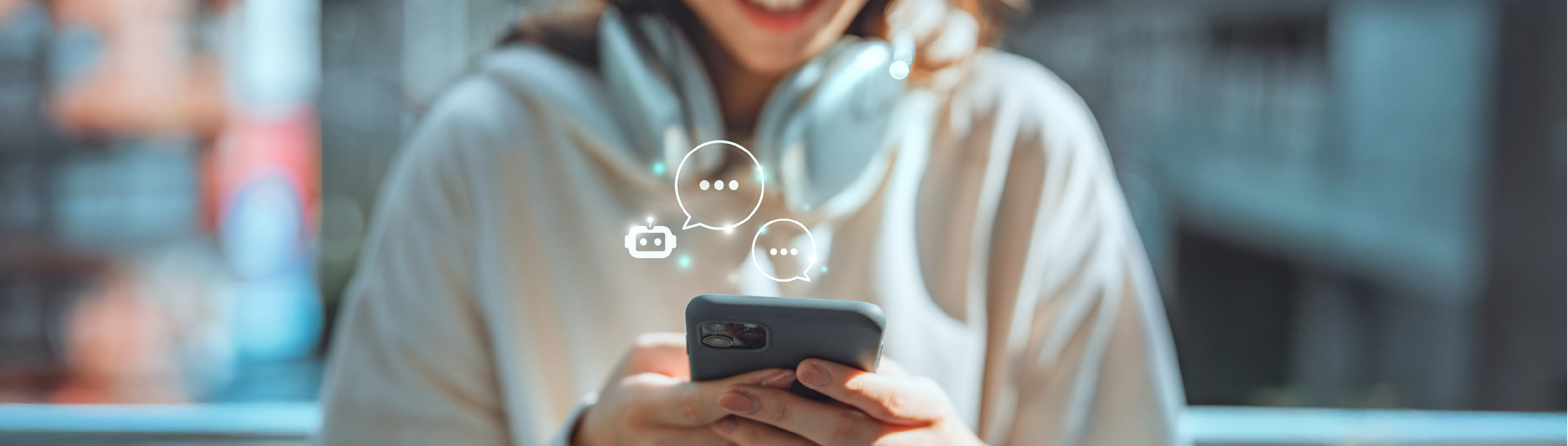 Ein Frau hält ein Handy in der Hand, auf welchem der Fokus des Bildes liegt. Über dem Handy sind Chatsymbole.