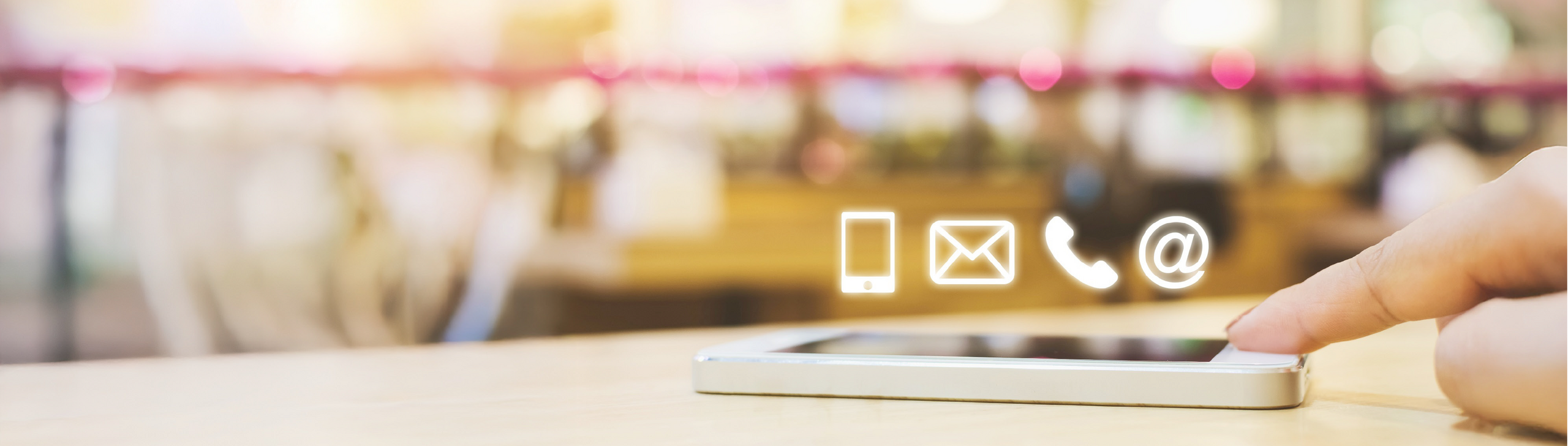 Kontaktsymbole über einem Handy, das auf dem Tisch liegt.