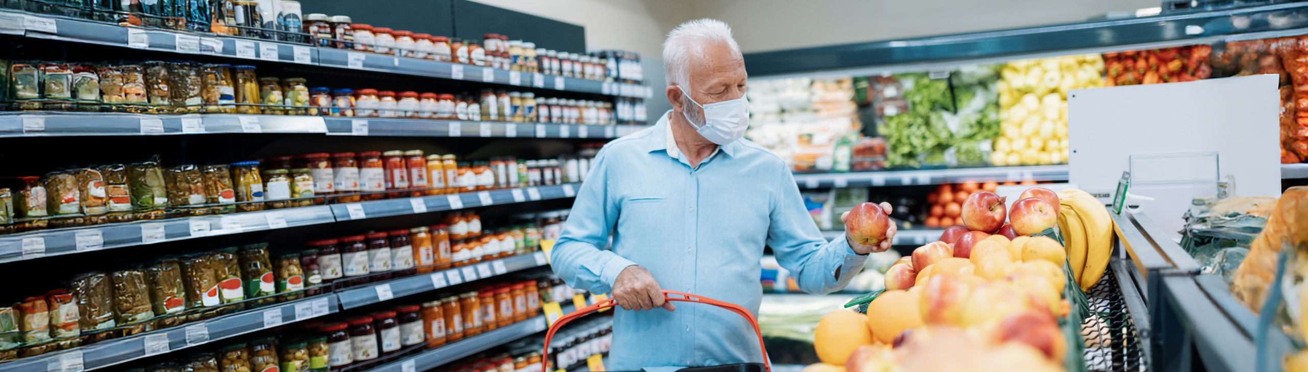Älterer Mann mit Maske beim Einkaufen im Supermart.