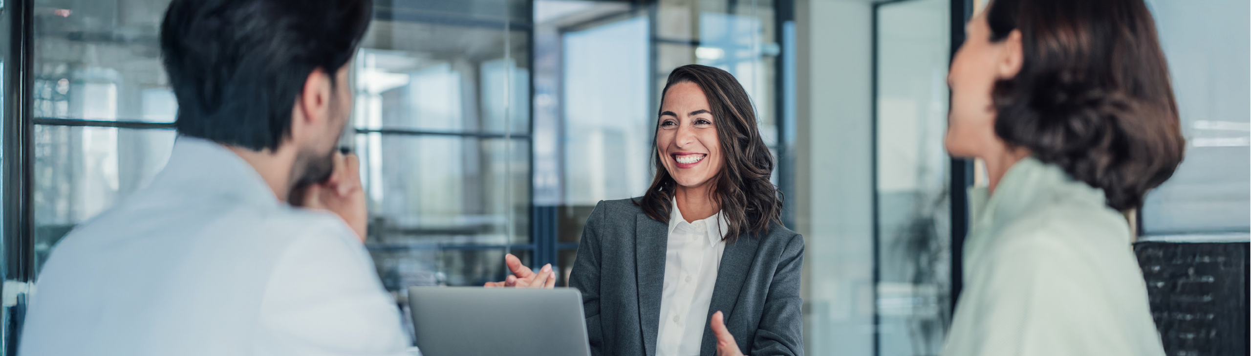 Eine Frau berät ein Ehepaar in einem Besprechungsraum.