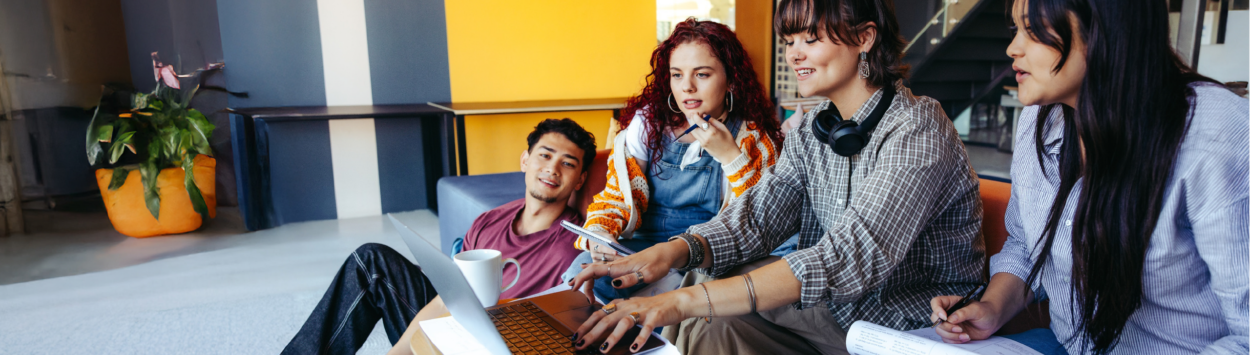 Eine Gruppe junger Leute sitzt vor dem Laptop und Recherchieren gemeinsam.