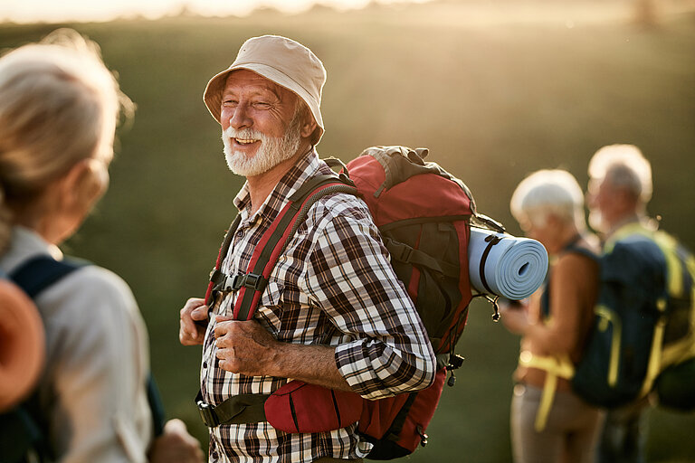 Älterer Mann mit Freunden beim Wandern.