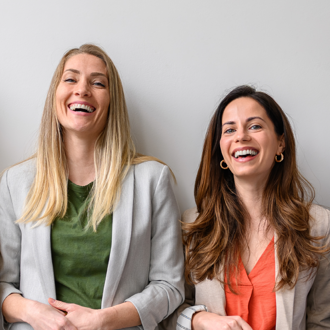 2 Frauen und ein Mann stehen in einer Reihe und lachen in die Kamera. 