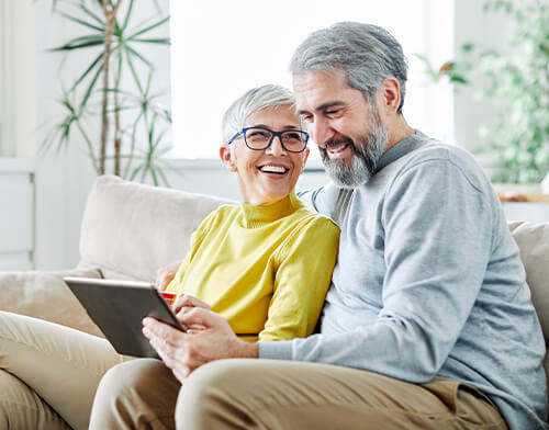 Glückliches Seniorenpaar benutzt ein Tablet