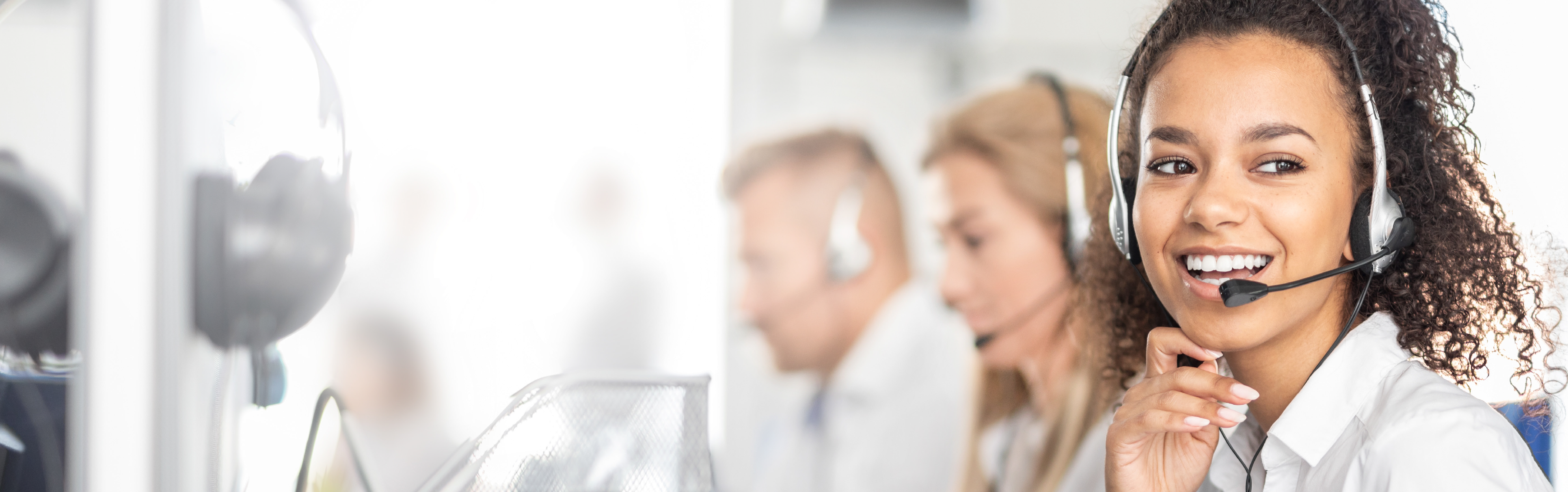 Eine Frau ist im Callcenter tätig und telefoniert gerade mit einer Person.