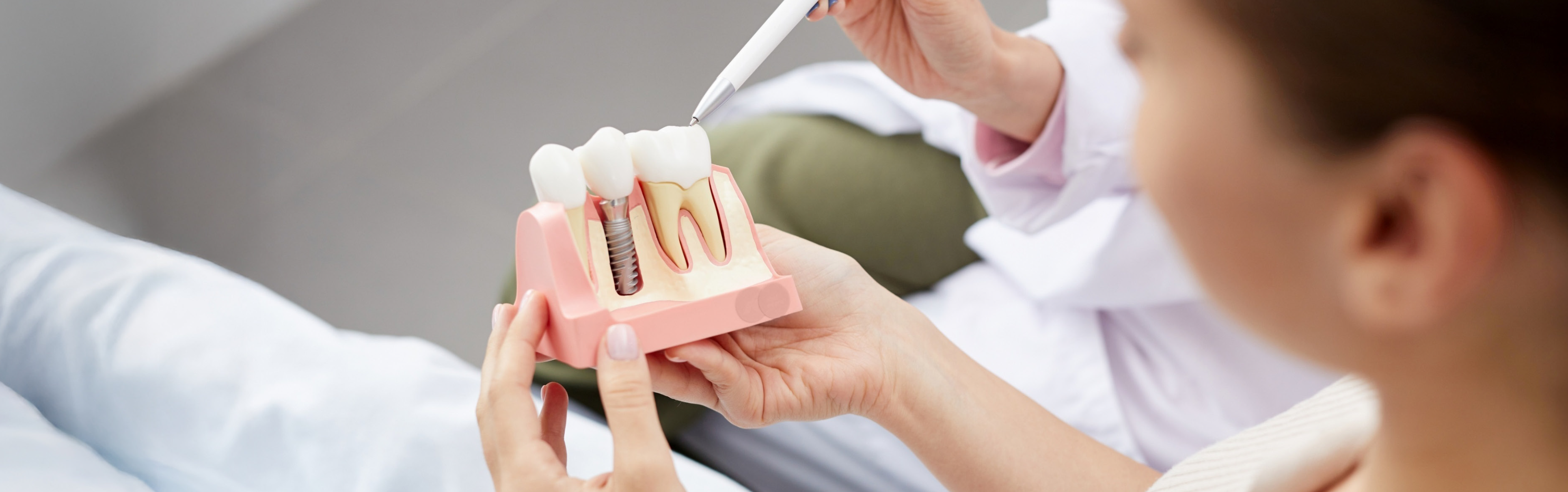 Zahnarzt erklärt einer Patientin die Vorgehensweise bei einem Implantat