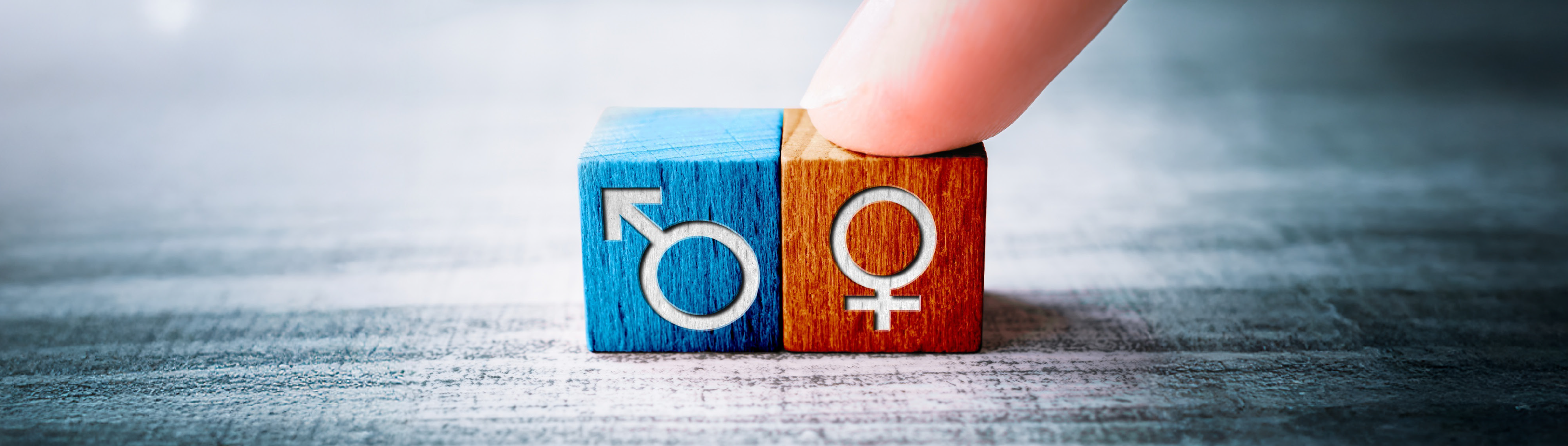 Geschlechtssymbole auf bunten Würfeln.