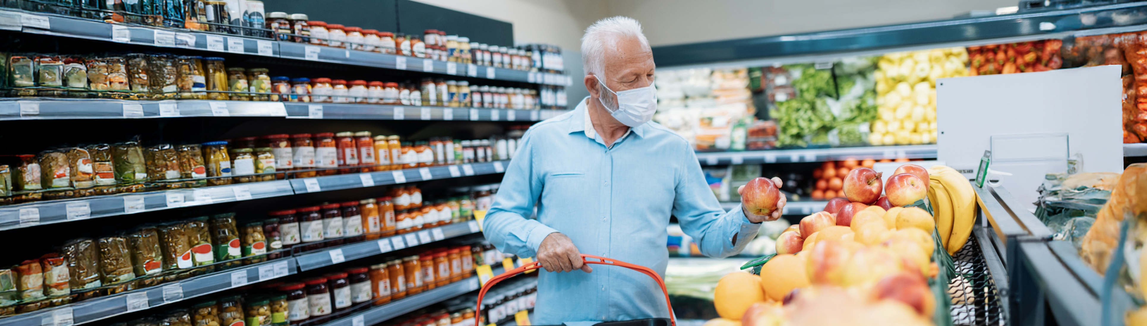 Älterer Mann mit Maske beim Einkaufen im Supermart.