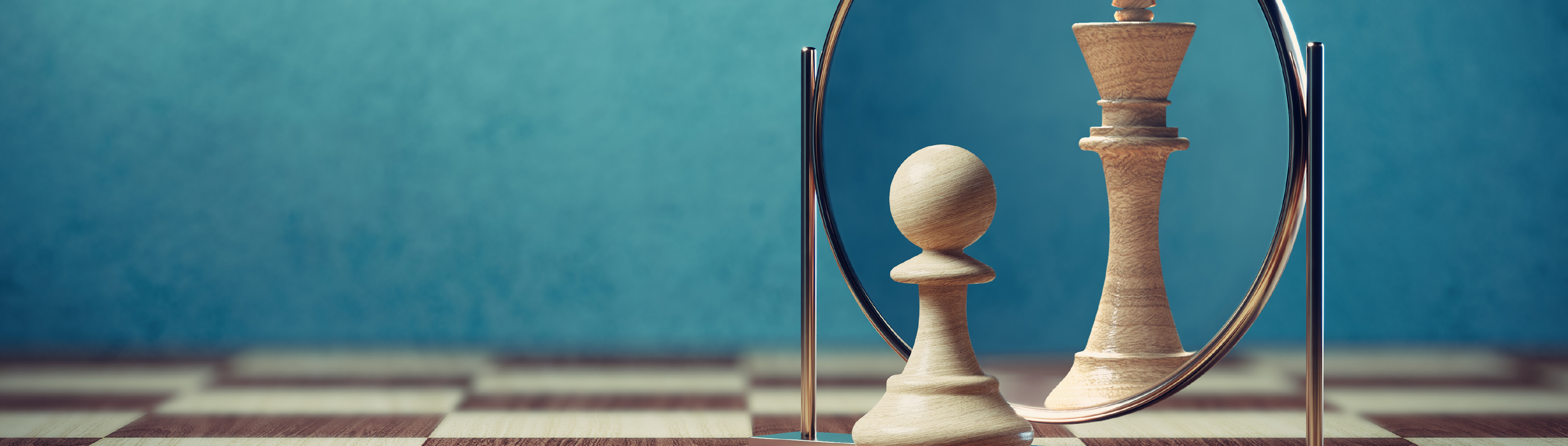 Bauer Schachfigur steht vor einem Spiegel. Im Spiegel ist die Schachfigur König zu sehen.