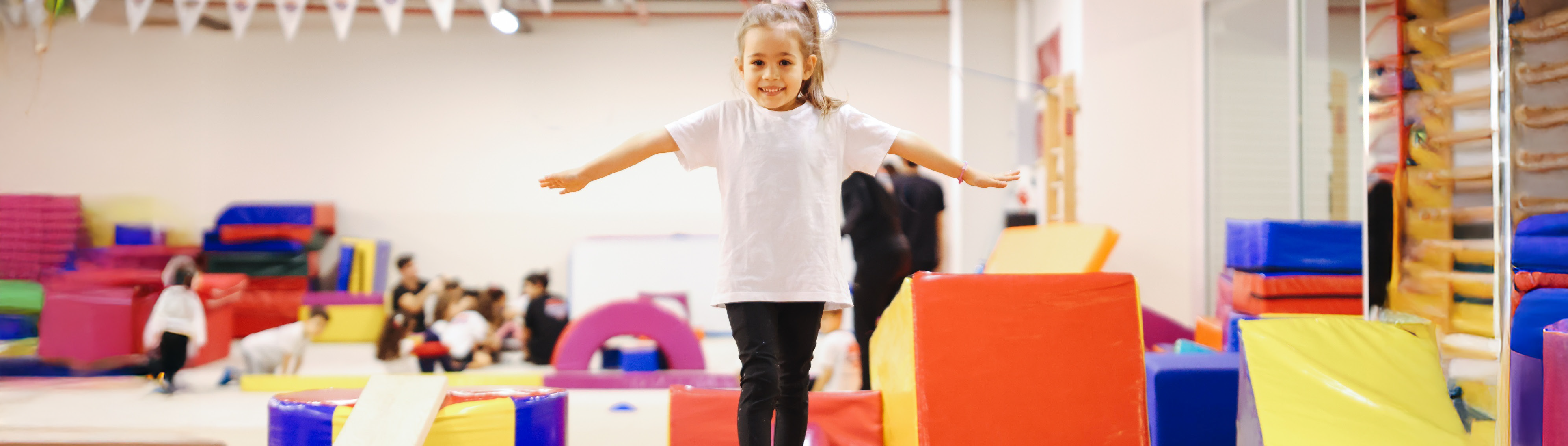 Mädchen macht Gymnastik in einer Turnhalle. 