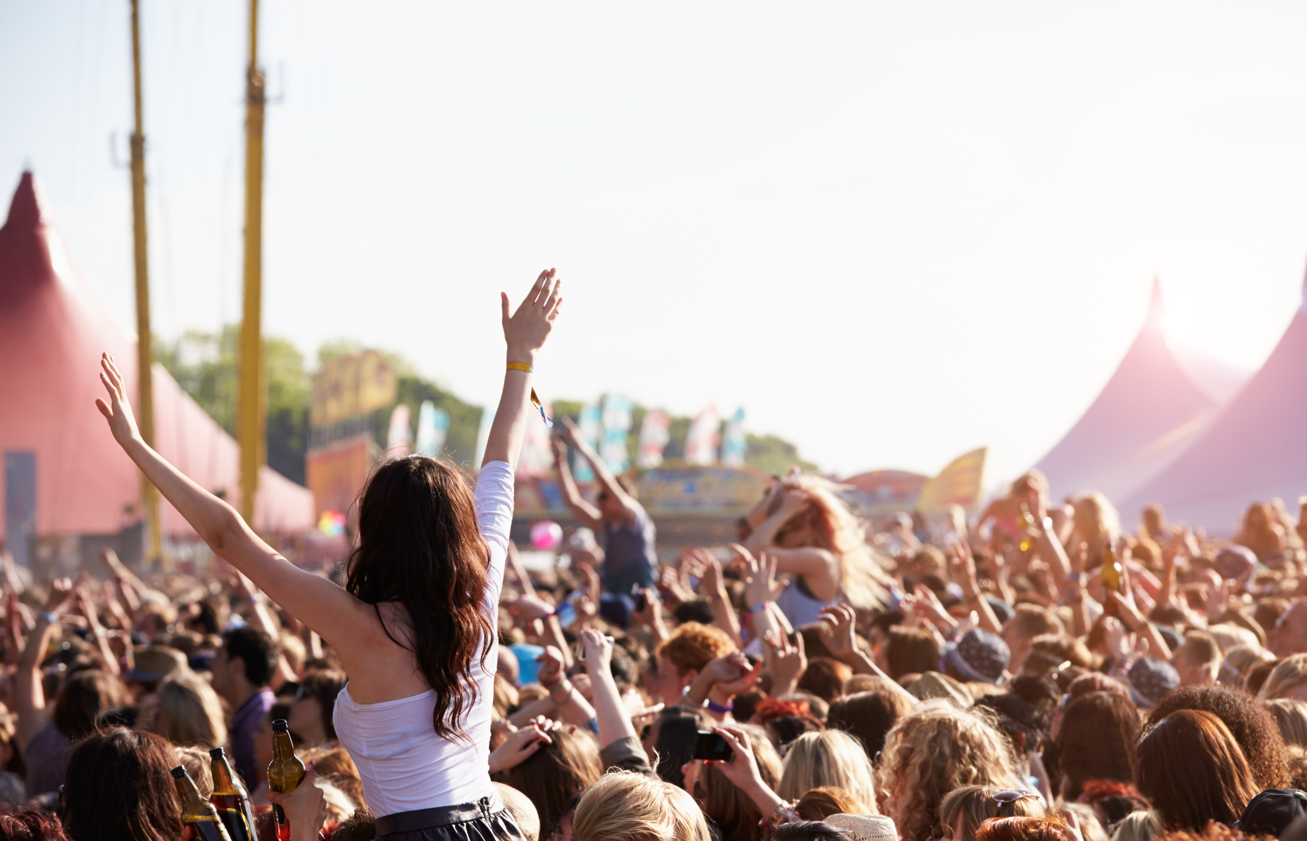 Menschenmenge auf einem Festival, ein paar Personen sitzen auf den Schultern anderer und feiern. 